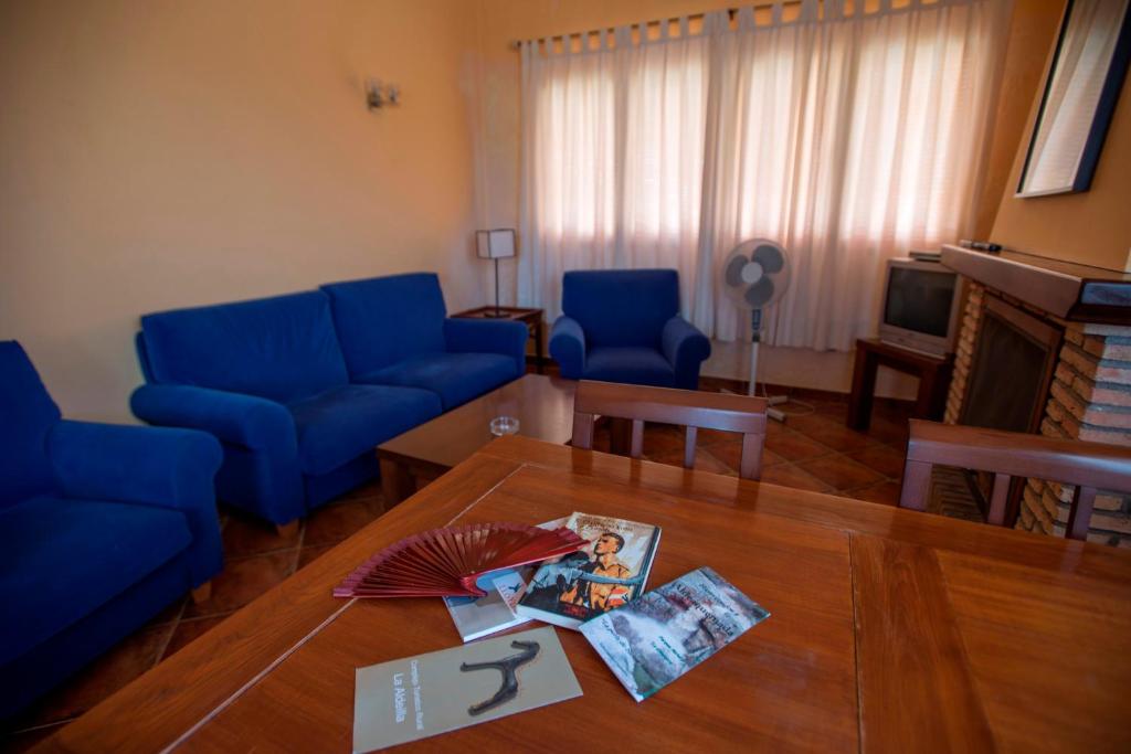 ein Wohnzimmer mit blauen Sofas und einem Tisch in der Unterkunft La Aldeílla in Aldeaquemada