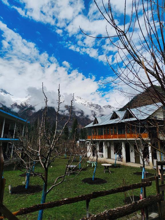 a building with a fence in front of it with mountains at The North Rememberzz in Kalgha