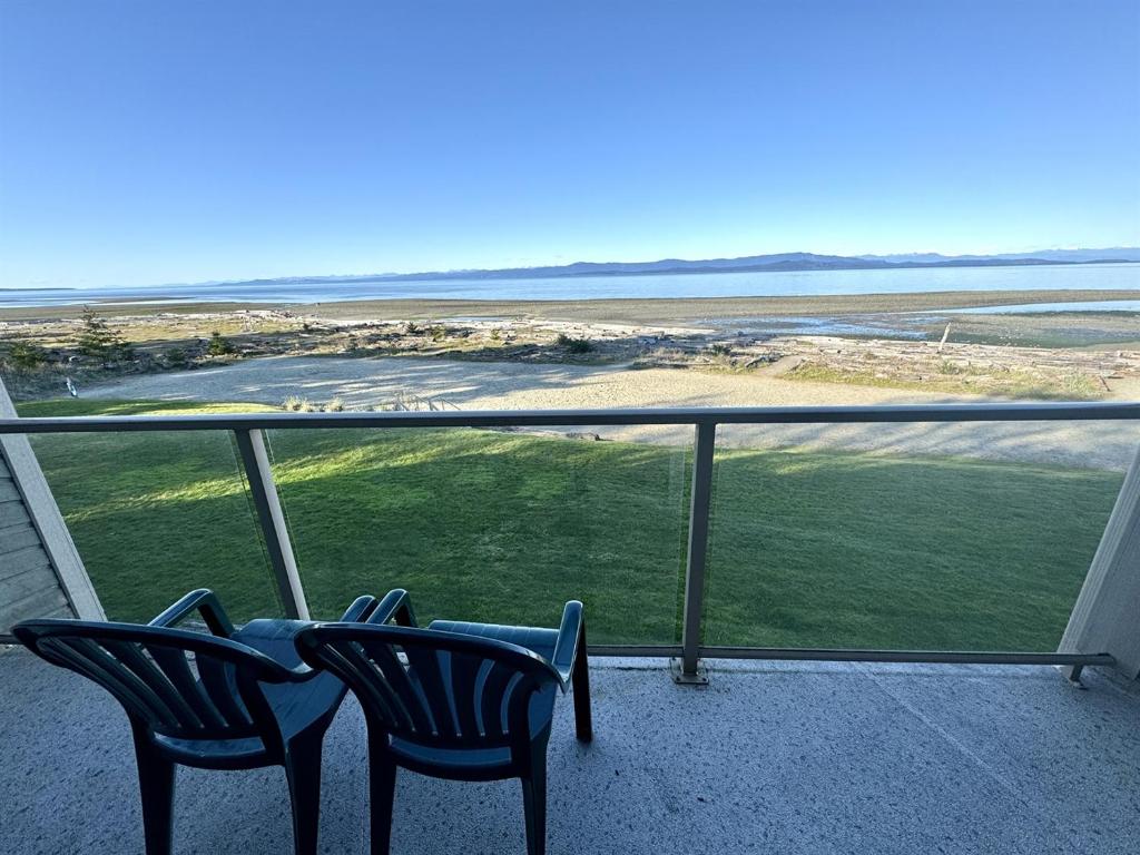 two chairs on a balcony with a view of the ocean at Oceanfront Studio with Loft - amazing views! in Qualicum Beach