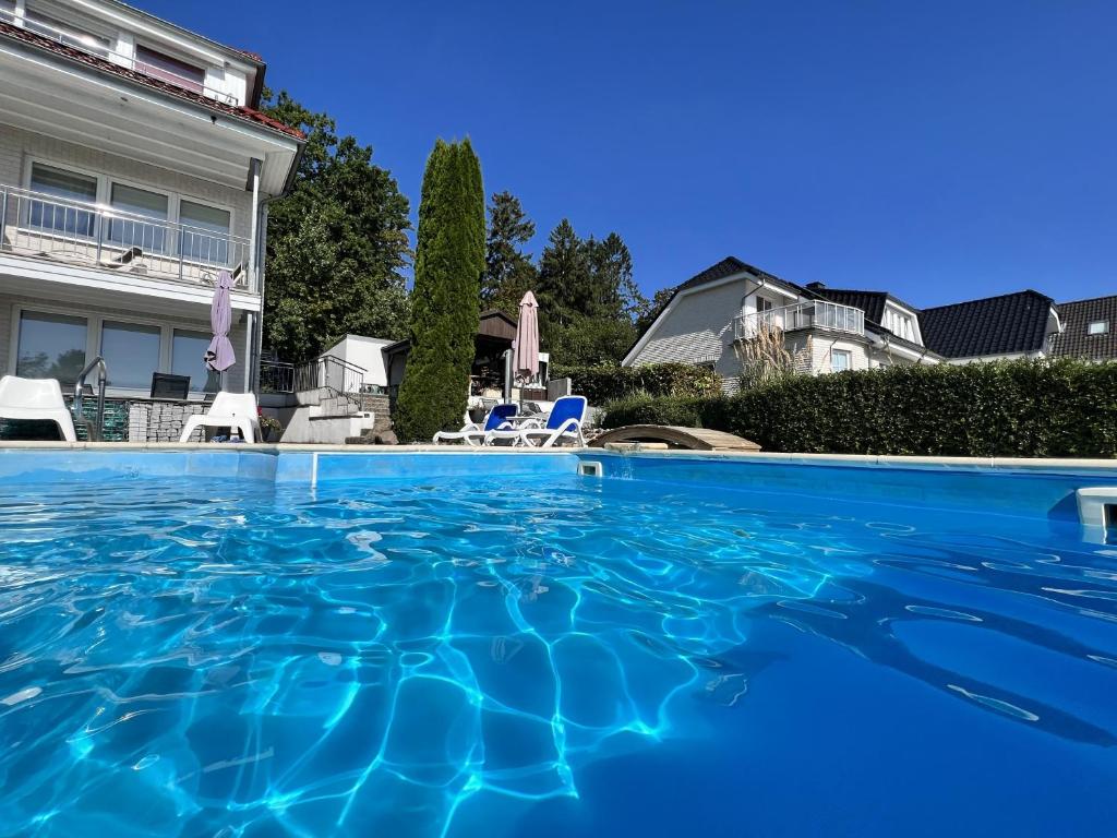 a swimming pool in front of a house at Villa Vogelsang VV, Schwimmbad, Sauna in Sierksdorf