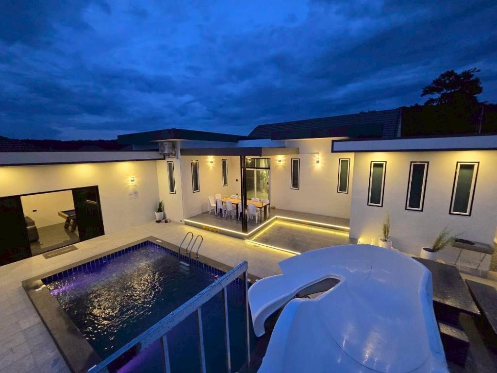 a house with a swimming pool at night at 65 Poolvilla in Ban Tao Than