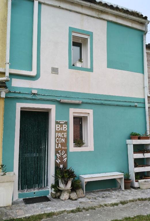a blue and white building with a bench in front at Pace con la natura in Casa Manara