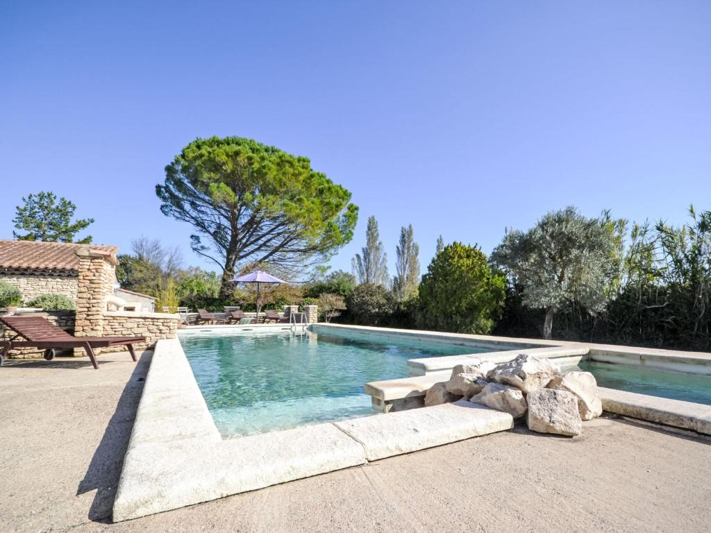 a swimming pool with a bench next to a house at Apartment Le Platane by Interhome in Velleron