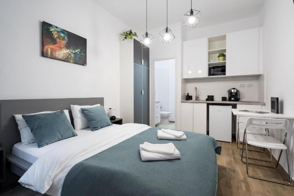 a bedroom with a large bed and a kitchen at RHUM B07 - Old Town Courtyard in Bucharest