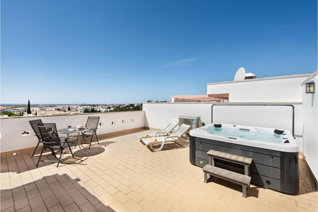a patio with a hot tub on a roof at Casa Brisa Tavira in Tavira