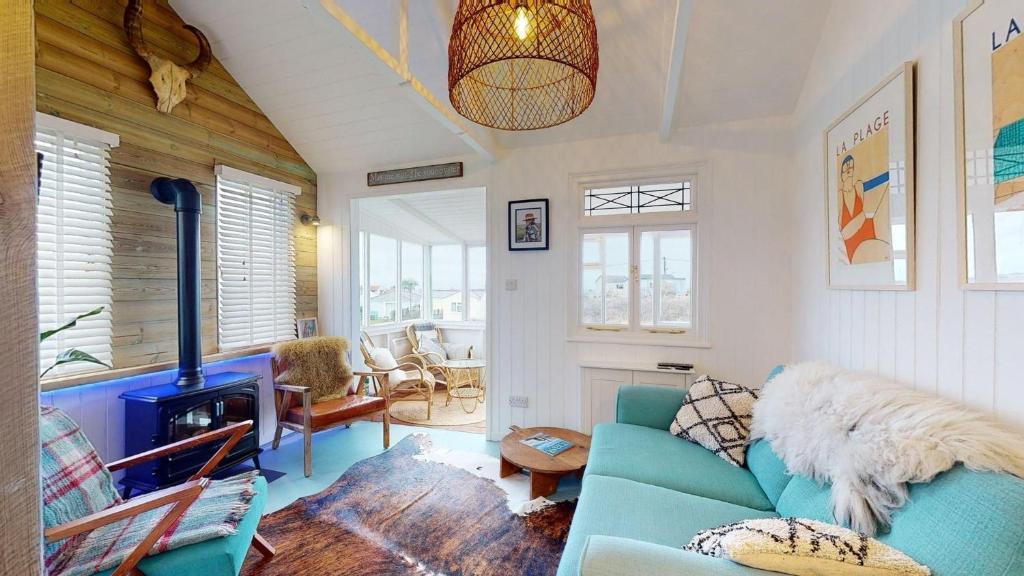 a living room with a blue couch and a fireplace at F12 West View, Riviere Towans in Hayle