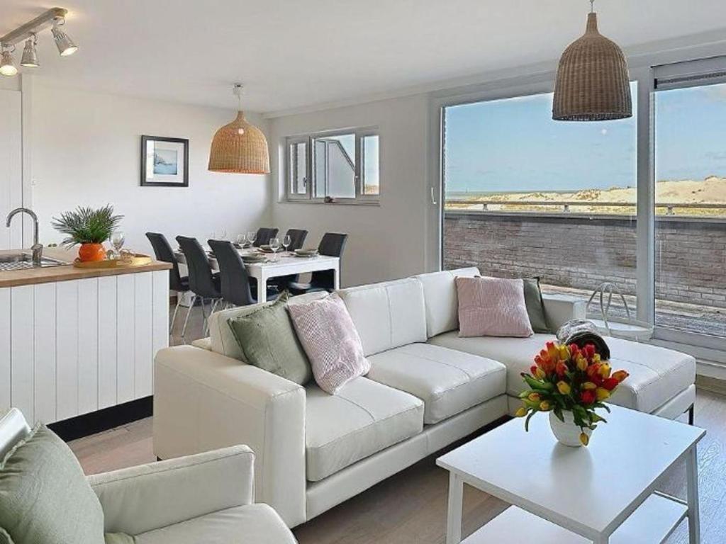 a living room with a white couch and a table at Apartment Albatros with parking by Interhome in Bredene