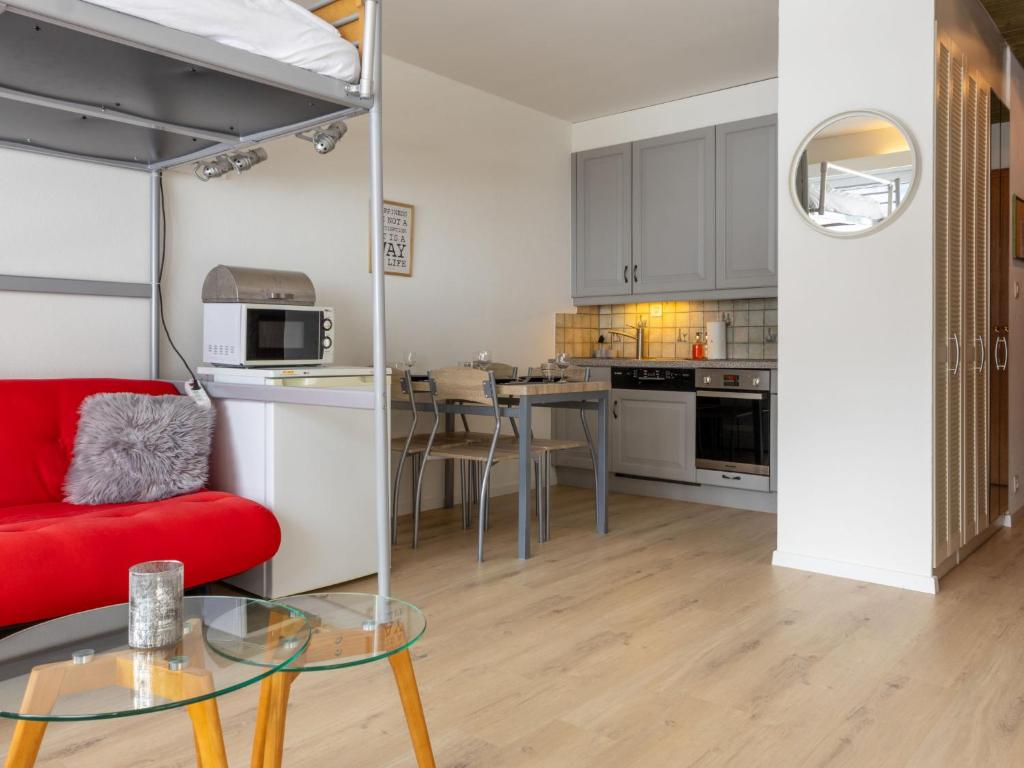 a living room with a red couch and a table at Studio Rosablanche D63 by Interhome in Siviez