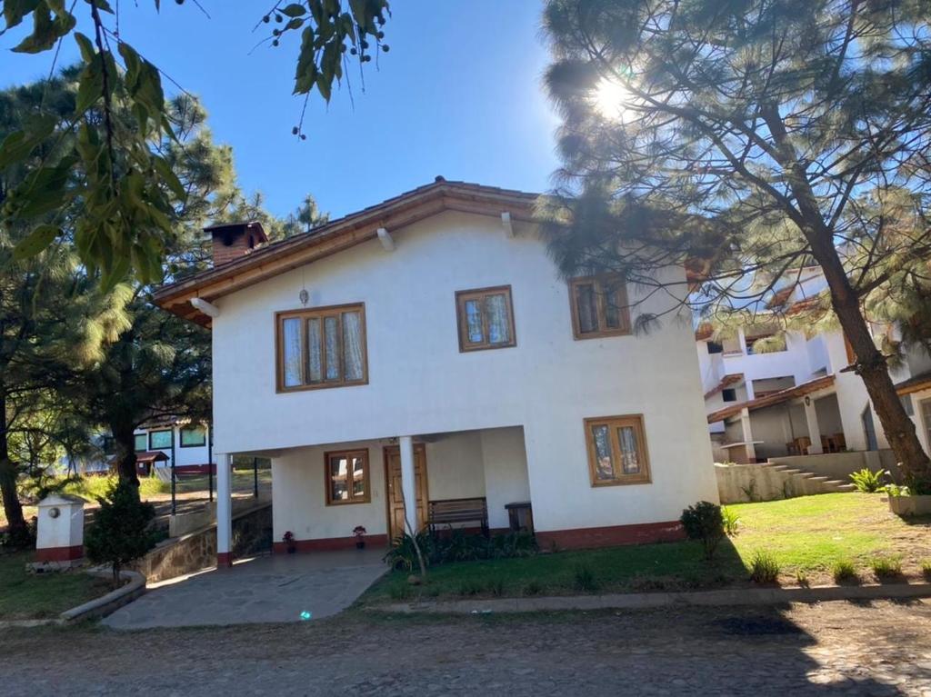 a white house with trees in front of it at Vistas NO 5 in Mazamitla