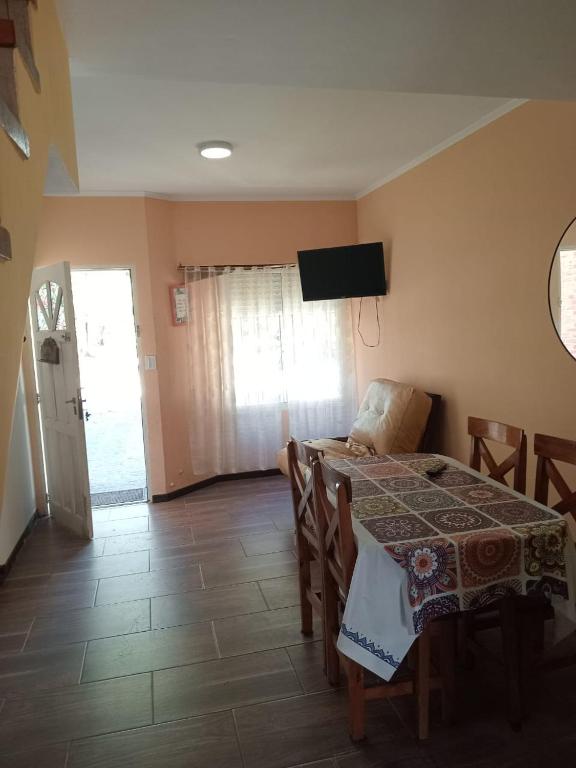 a dining room with a table and a television on the wall at Duplex a pazos del muelle in Mar de Ajó