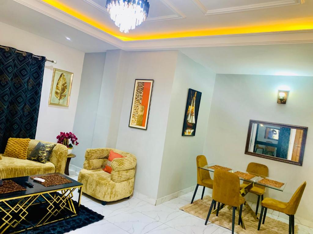 a living room with a couch and a table and chairs at KMC Guest House in Douala