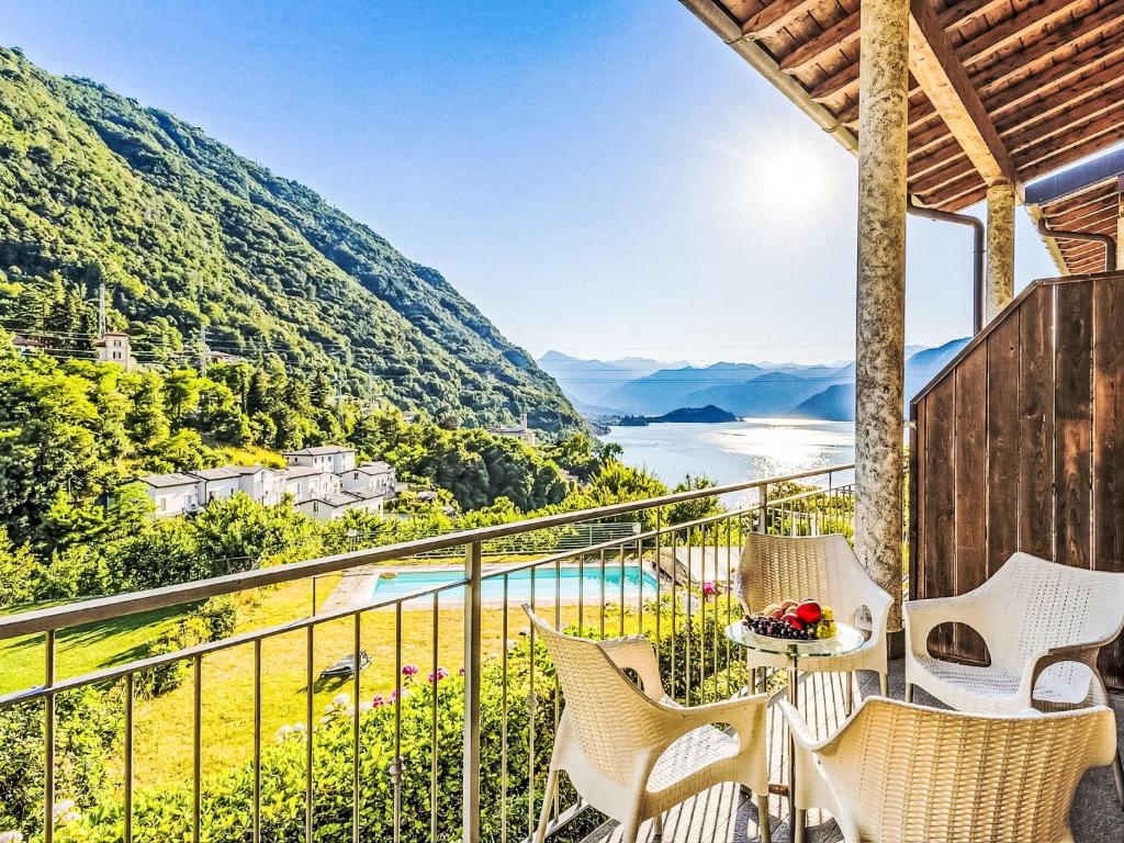 a balcony with chairs and a table with a view at Apartment Borgo Castello-4 by Interhome in Argegno