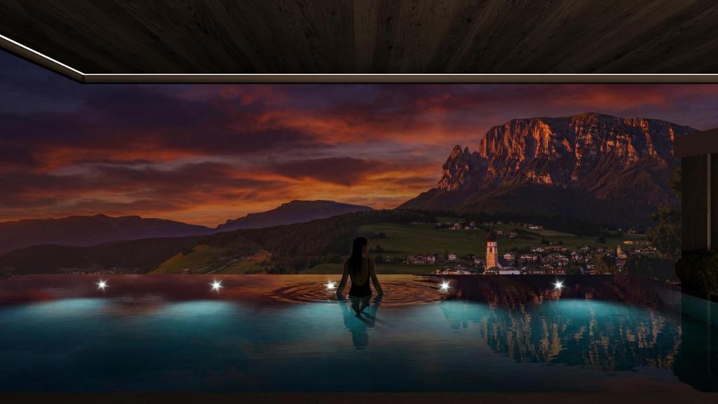 a woman walks in front of a painting of a mountain at LeFie in Vols am Schlern