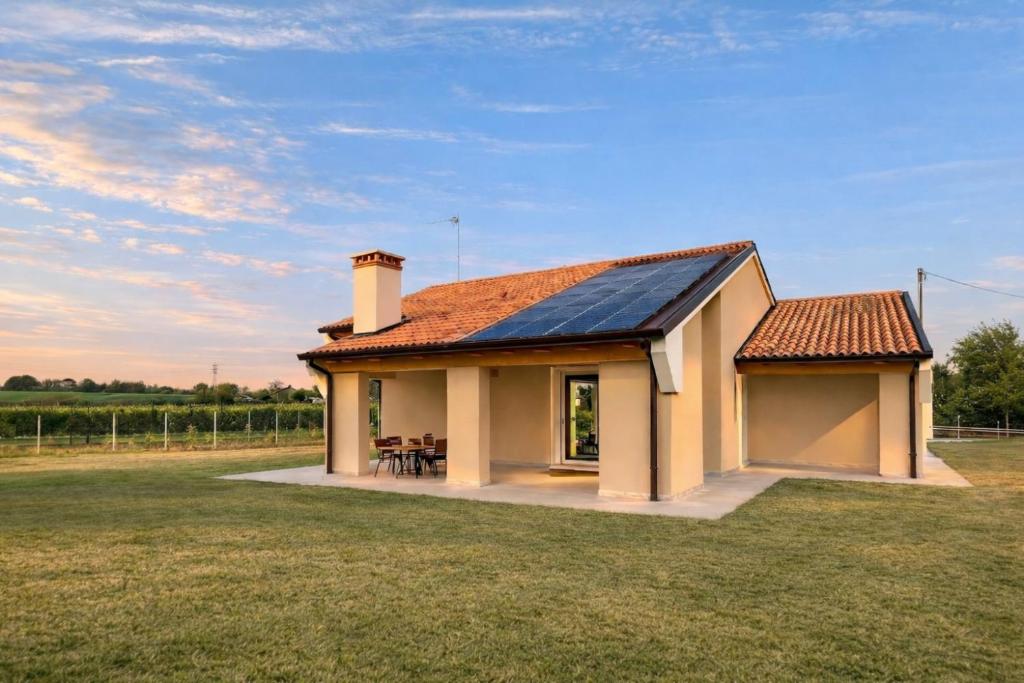a small house with a solar roof on a field at Villa Alberti - Elegant, Spacious & Bright Villa in Casa Reali