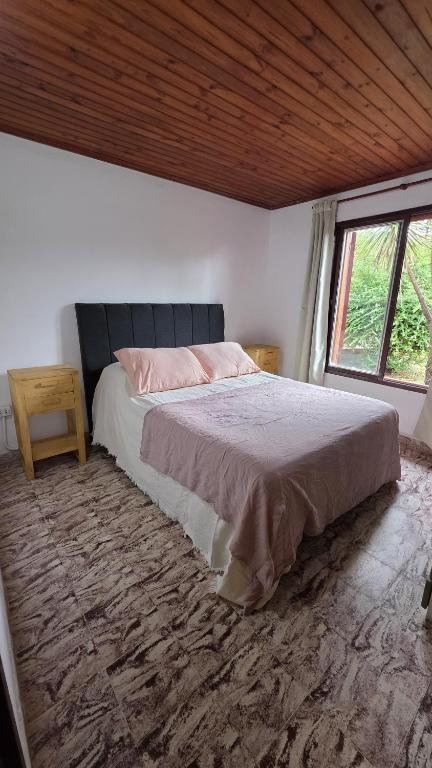 a bedroom with a bed and a large window at CASA ANTONIA in Embalse