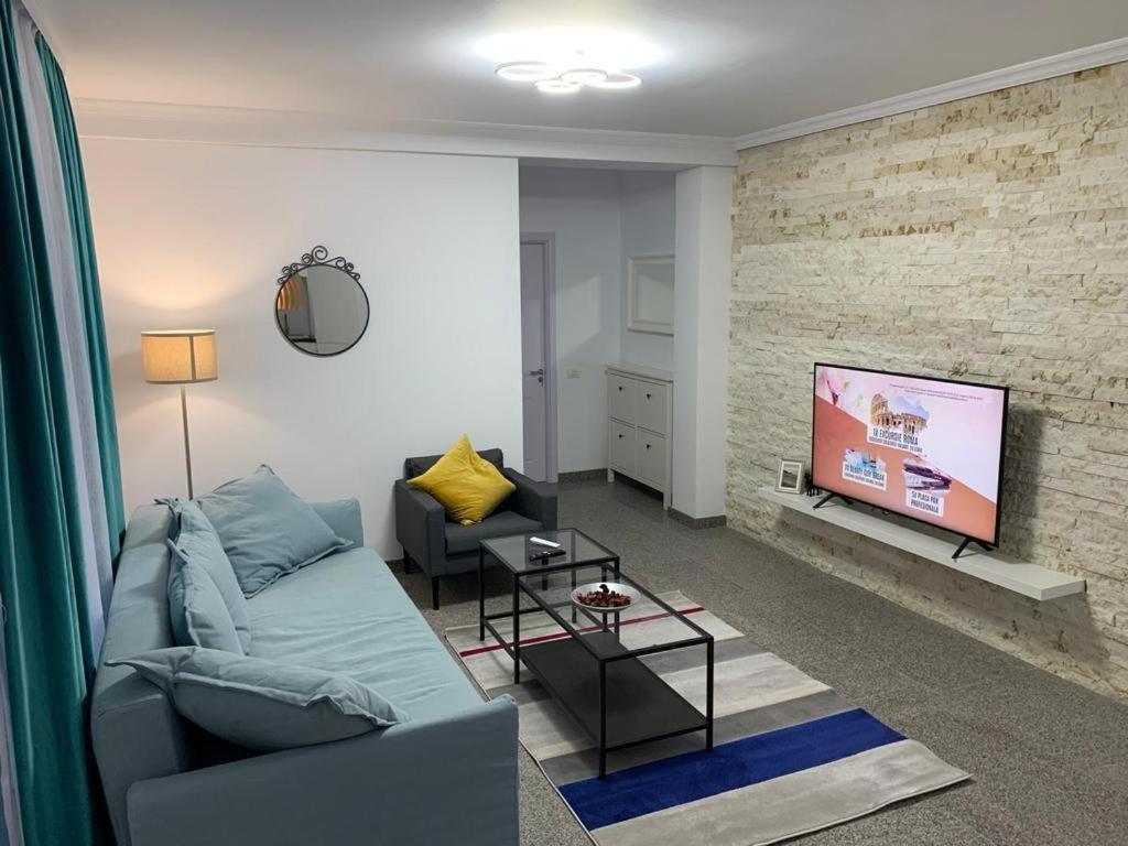 a living room with a couch and a tv at PP Apartments Deluxe in Năvodari
