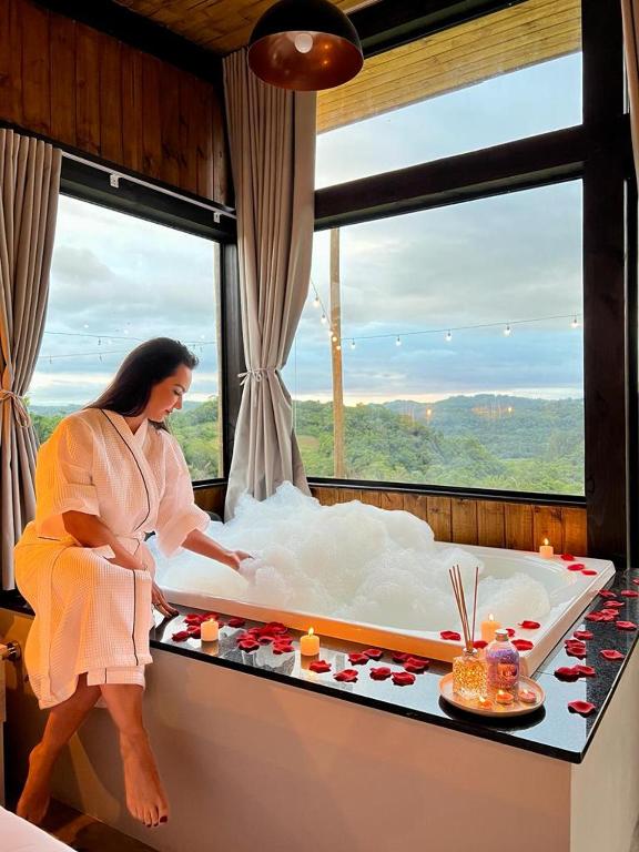 a woman in a bed in a room at Cabanas Monte Belo in Santa Cruz do Sul