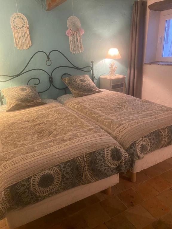 a bedroom with a bed and a lamp and a window at Le PHoenix in Roquestéron