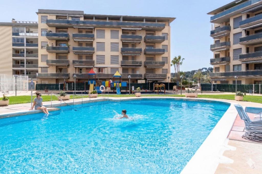 a person swimming in a swimming pool in front of a building at Mediterranean Way - Maldivas in La Pineda