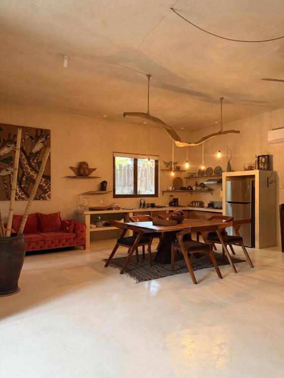 a living room with a table and a kitchen at Casa Nikau Chic Getaway in El Cuyo in El Cuyo