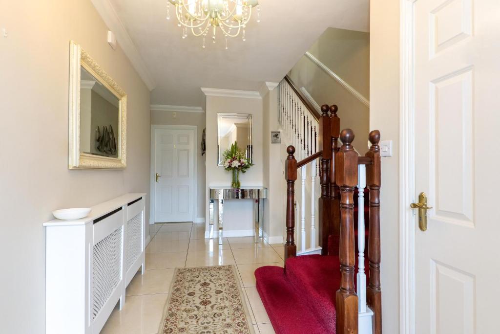a hallway with a staircase with a red rug at Sea Mist Guesthouse in Galway