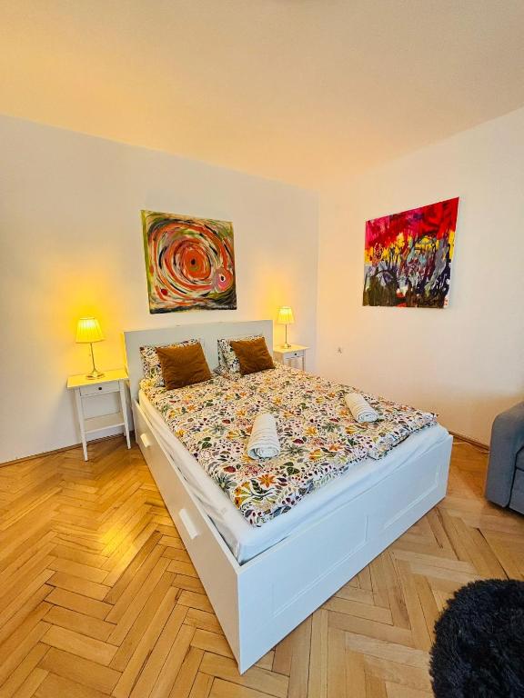 a bed in a room with two lamps and a painting at Gdynia Abrahama 48 in Gdynia