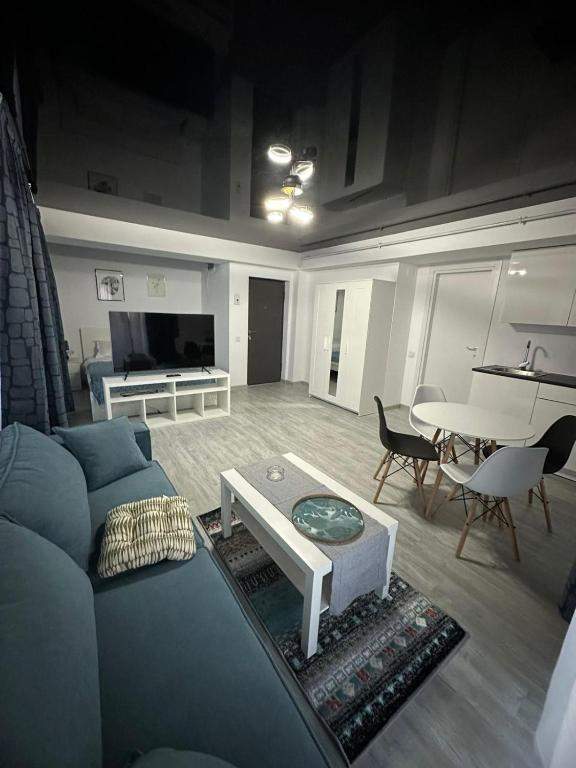 a living room with a blue couch and a table at Tower Apartments A6 in Năvodari