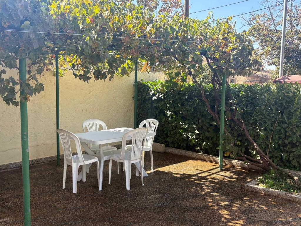 a white table and chairs under a pergola at Appartement Les Rosiers in Ifrane