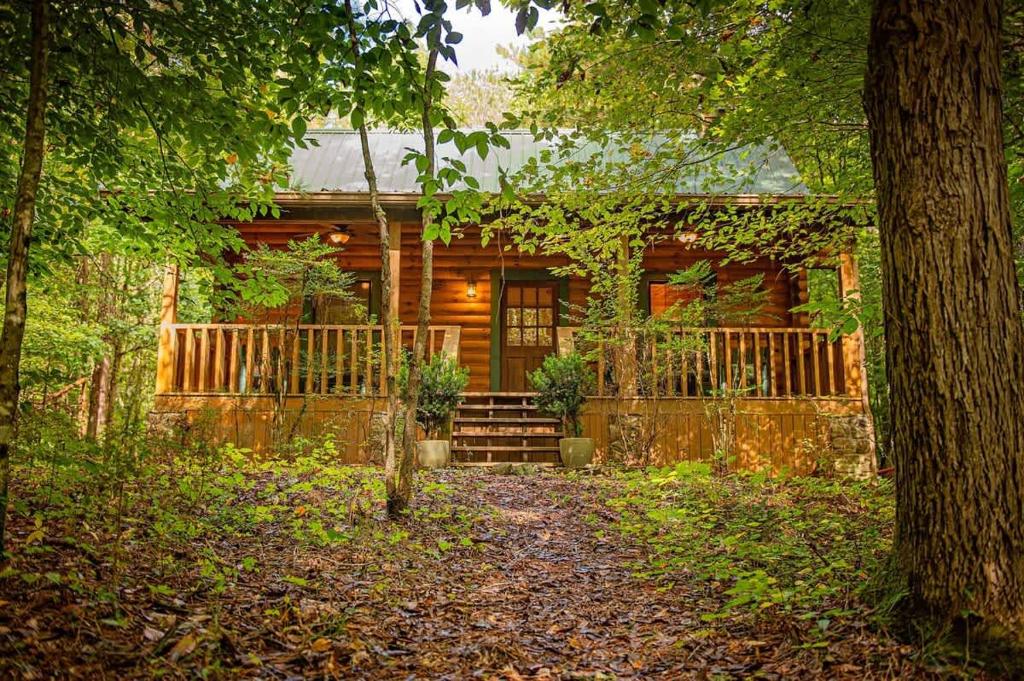 a log cabin in the woods with a porch at Cherokee Ridge Cabin Near The Ocoee River in Ocoee