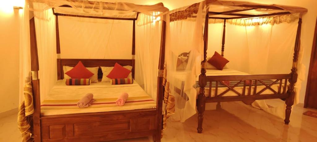 a bedroom with two bunk beds with red pillows at Freedom Life Yala in Tissamaharama