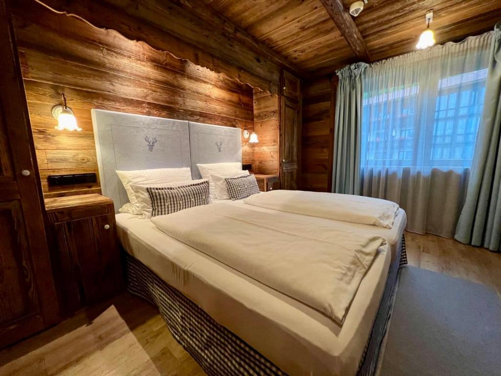 a bedroom with a large bed in a wooden room at Luxus Chalet in Oberstaufen inkl Wellness Pool und Bergbahnen in Oberstaufen