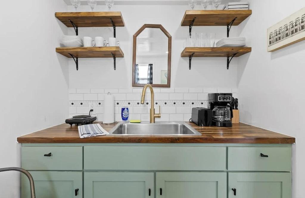 a kitchen counter with a sink and a mirror at Quail Run Farm- Rustic Tiny Home 2 in Chattanooga