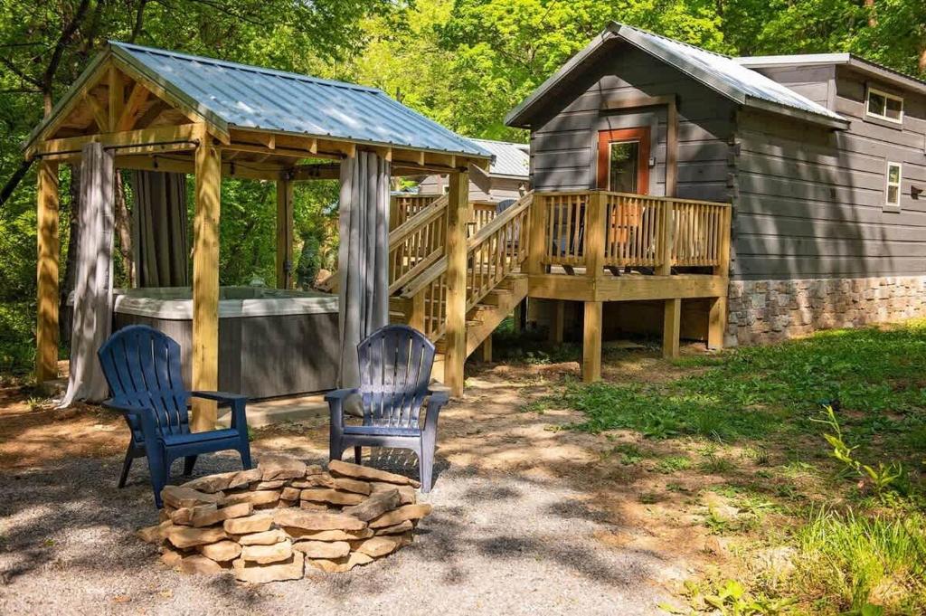 a cabin with two chairs and a wooden deck at Meg Cabin Tiny Rustic Comfort On Lookout Mtn in Chattanooga