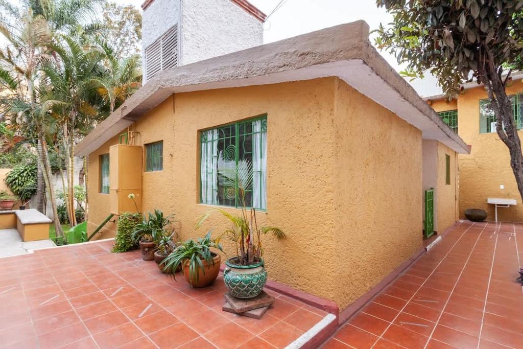 a house with potted plants in front of it at El Apapacho in Cuernavaca