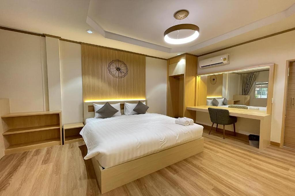 a bedroom with a bed with a clock on the wall at BB house & resort in Ban Thum