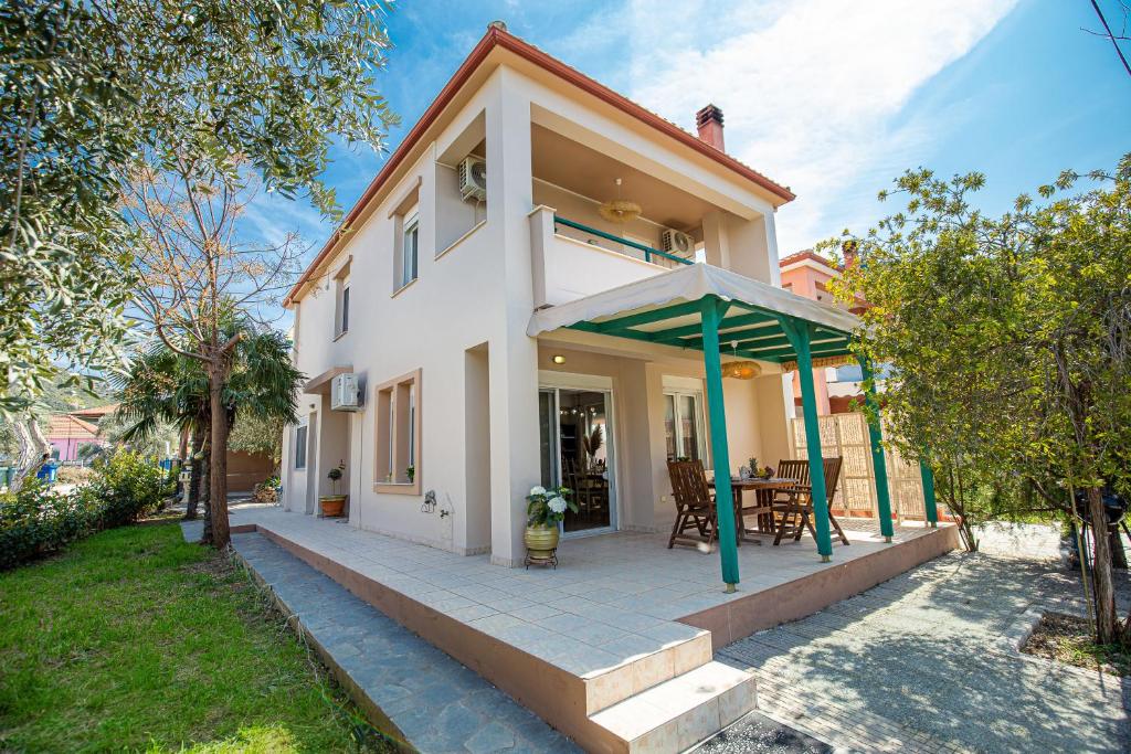 a white house with a patio and a table at Villa Aurum in Prinos