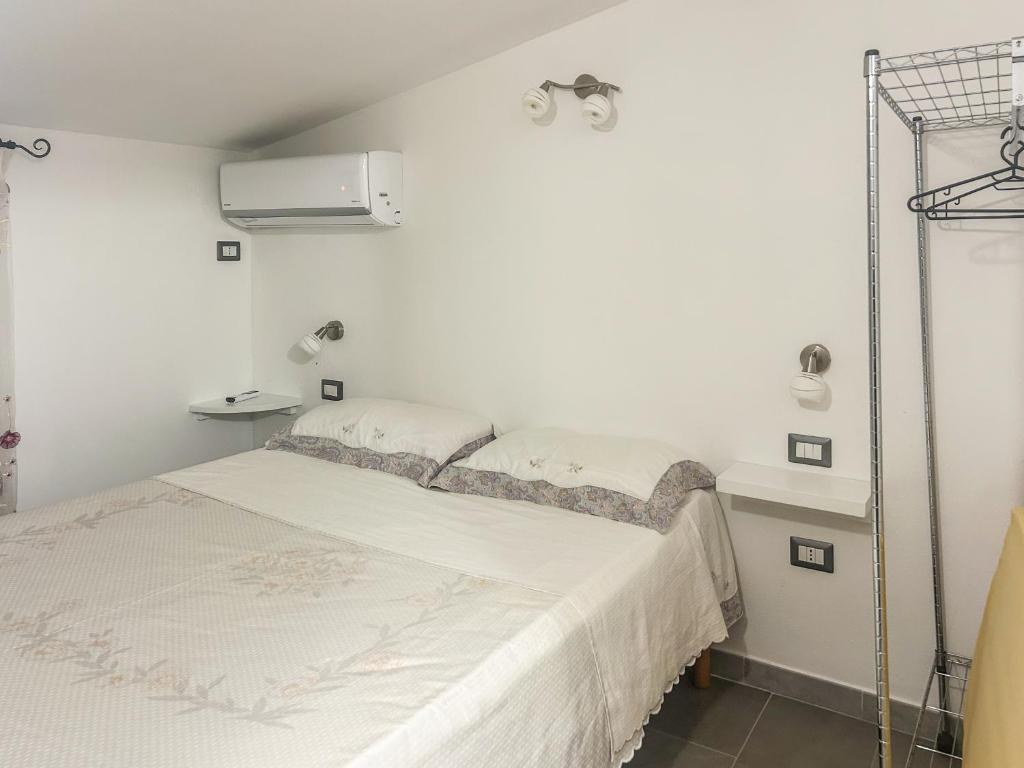 ein weißes Schlafzimmer mit einem Bett und einer weißen Wand in der Unterkunft Annarosa08 in Sorso
