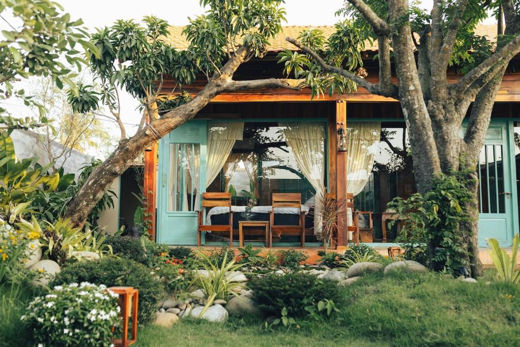 a house with a table and chairs in a garden at Đàng Trong Home 2 in Xóm Rạch Rô