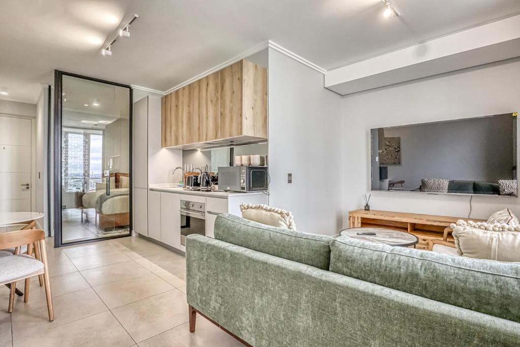 a living room with a couch and a kitchen at Caica Executives at Ellipes 4202 in Midrand