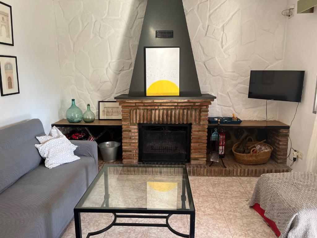 a living room with a couch and a fireplace at Casa Rural Tazgona in Antequera