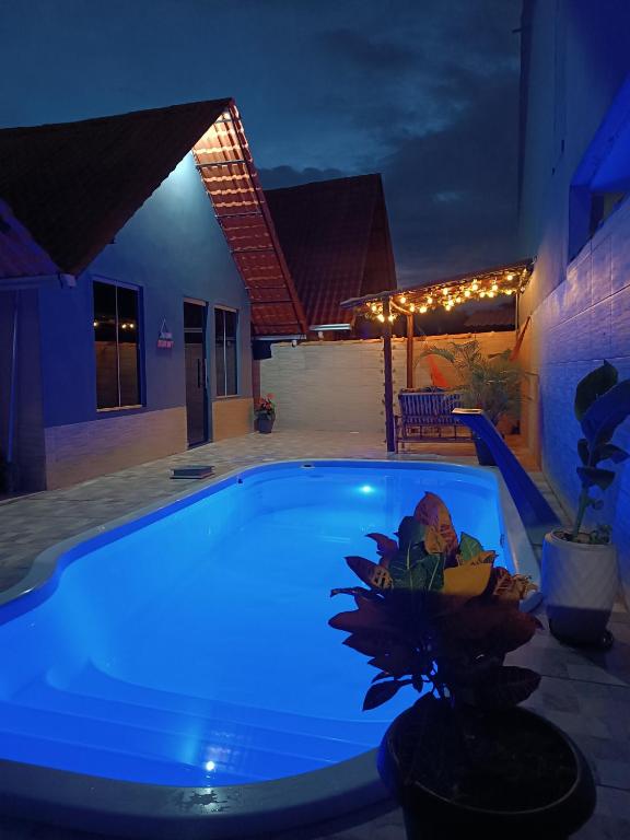 a swimming pool lit up at night at Chalé Montanhez com ar e piscina in Caparaó Velho