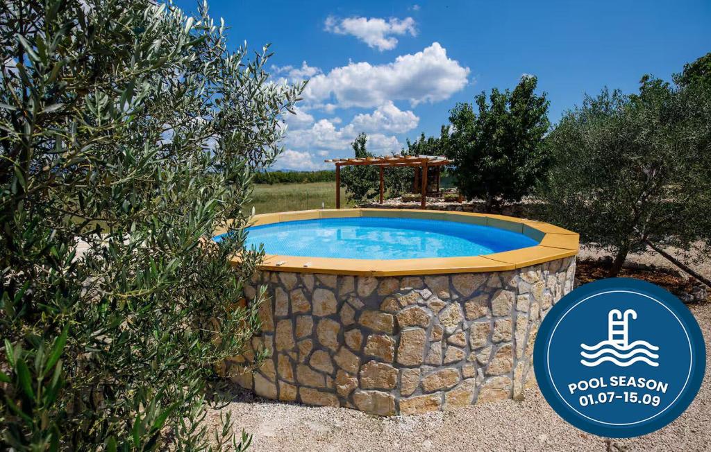 a large pool with a stone wall around it at House Mala kuca in Oklaj