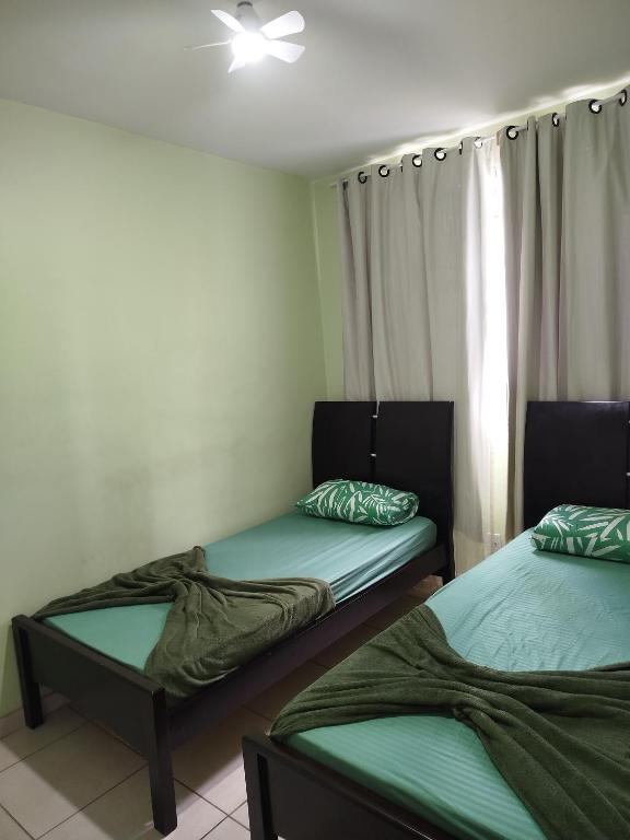 two twin beds in a room with a window at Apt 3Q Confort Aeroporto Confis Próx Cid Galo e Cid Admininstrativa Gov in Vespasiano