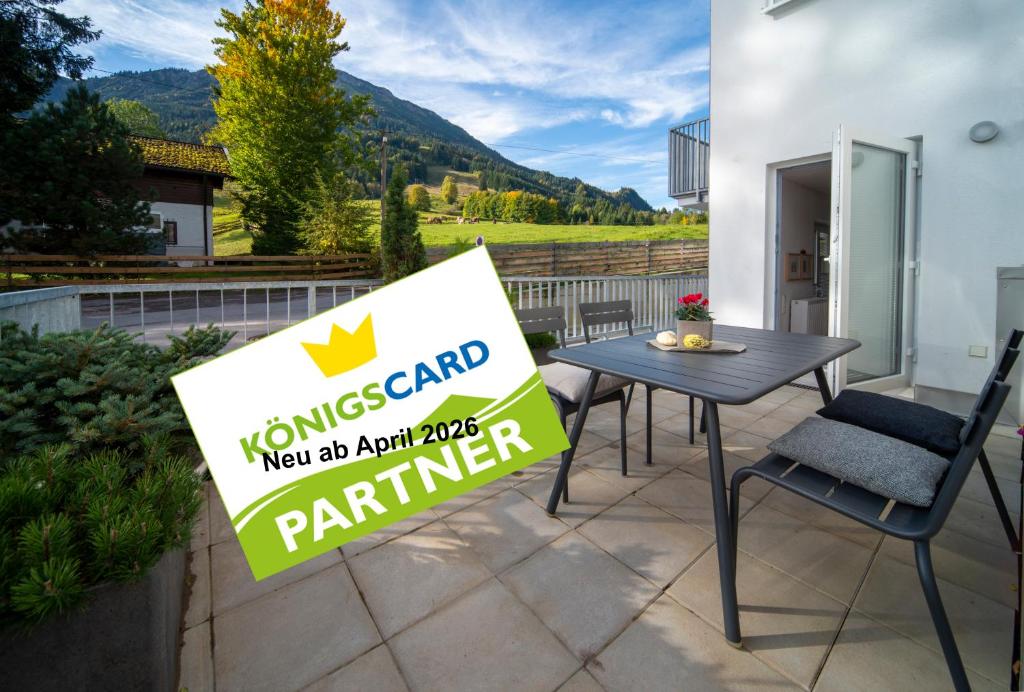 a sign on a patio with a table and chairs at Chalet am Breitenberg Apt1 in Pfronten