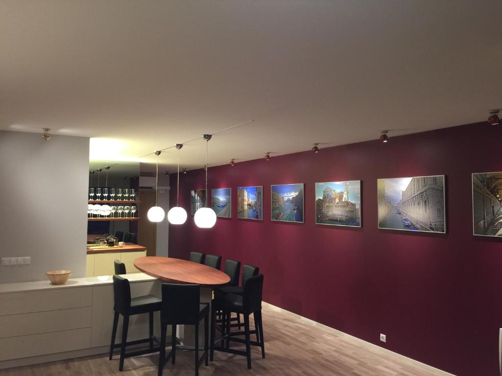 Liiva Seaside Apartment في هابسالو: غرفة طعام بجدار احمر مع طاولة وكراسي