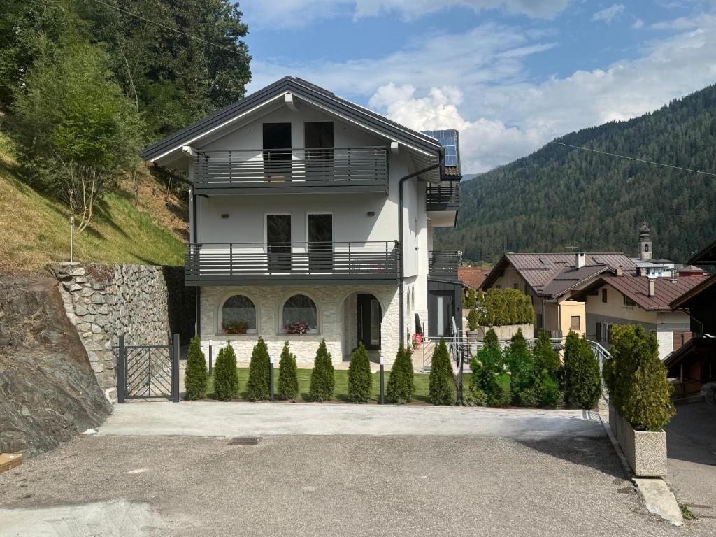 a white house with a fence in front of it at Al Piz - Dimora Alpina in Pellizzano