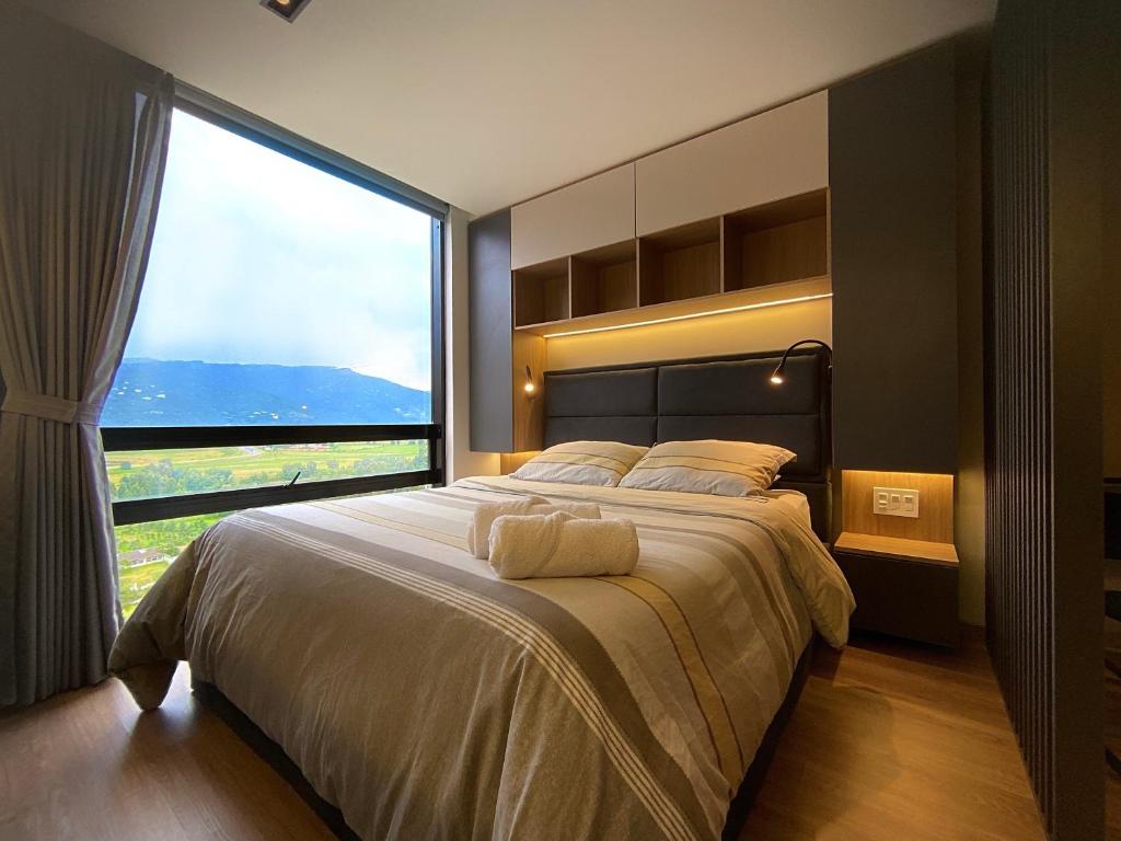 a bedroom with a large bed with a large window at GV Aparta Suites - Centro Chía in Chía