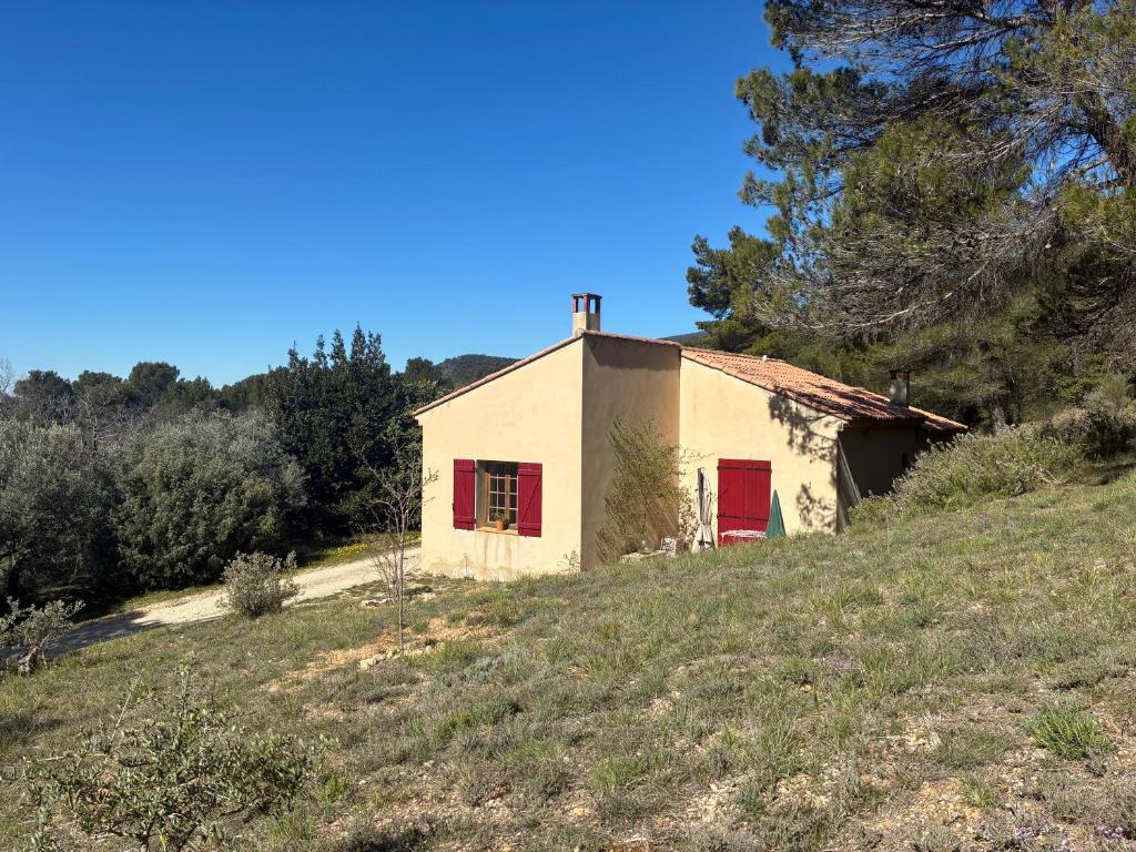 an old house on a hill with red shutters at Maison de l'Hermitage in Cucuron