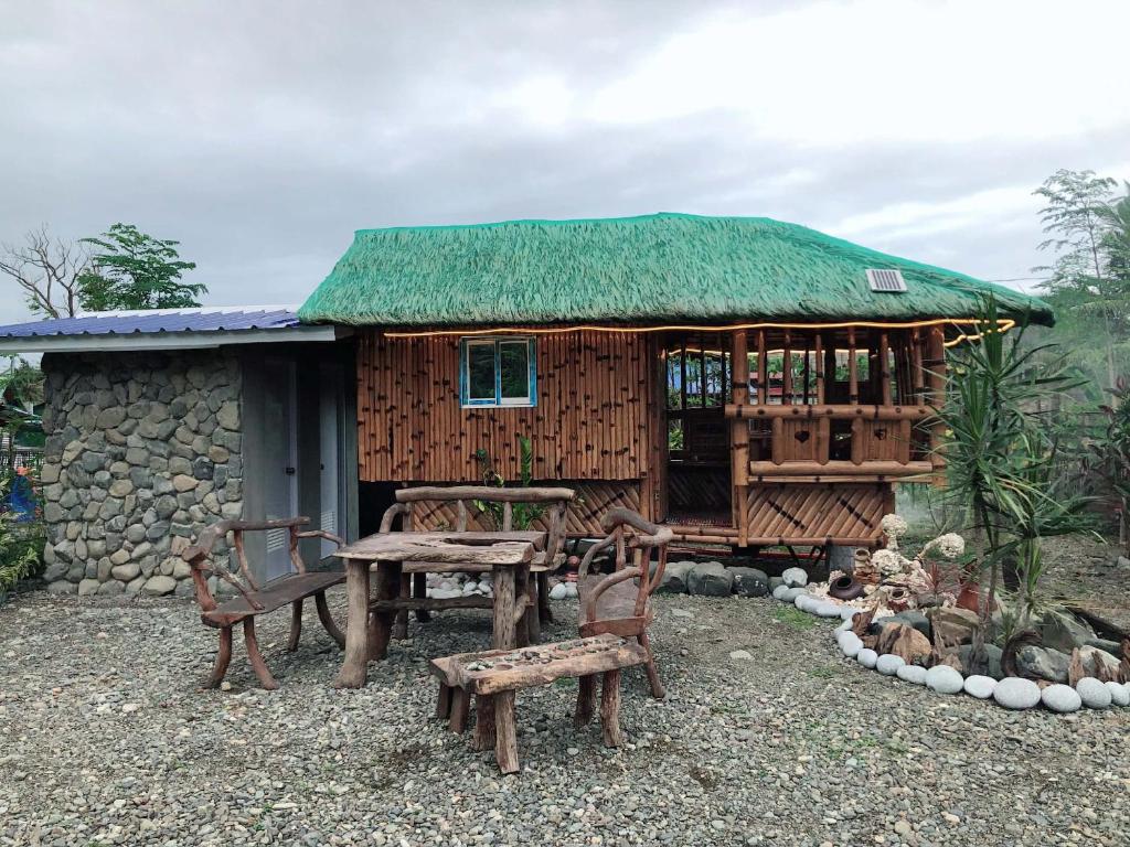 a hut with a table and chairs in front of it at Maybeth Haven Cabin in Baler