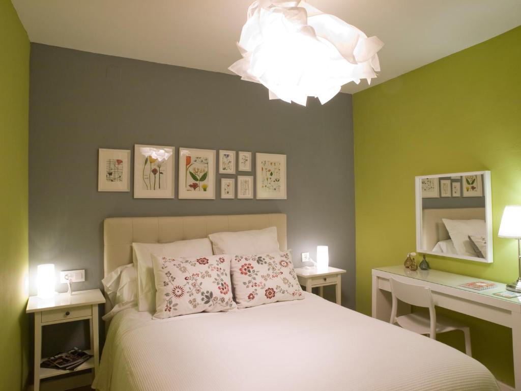 1 dormitorio con cama y lámpara de araña en La casa del arbol, en Cuenca